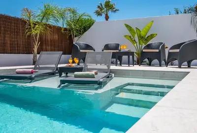 a pool with chairs and a table next to a swimming pool at Villa Paradisius by Algarve Vacation in Albufeira