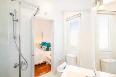 a white bathroom with a shower and a toilet at Villa Paradisius by Algarve Vacation in Albufeira