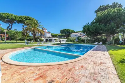 a swimming pool in a yard with trees at Vilamoura - M M GARDEN - Magnifico T2 in Vilamoura