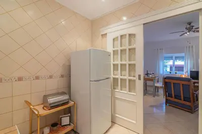 a kitchen with a refrigerator and a dining room at Vilamoura - M M GARDEN - Magnifico T2 in Vilamoura