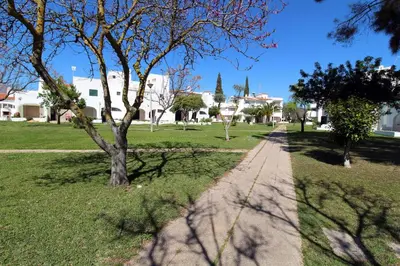 a path in a park with trees and buildings at Charming Villa by SAPvillas in Vilamoura