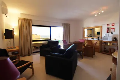 a living room with a couch and chairs and a kitchen at Marina Mar Light by SAPvillas in Vilamoura