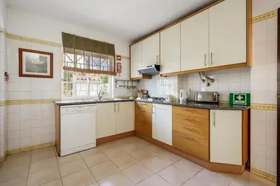 a small kitchen with white cabinets and a sink at Villa Mianas by SAPvillas in Vilamoura