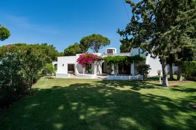 a white house with flowers on the front yard at Villa Serendipity by SAPvillas in Vilamoura
