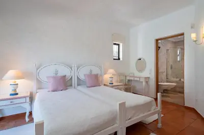 a bedroom with a white bed and a bathroom at Villa Serendipity by SAPvillas in Vilamoura