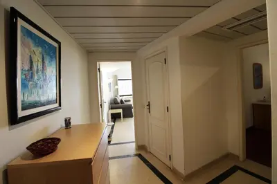 a living room with a table and a painting on the wall at Marina Mar Marina by SAPvillas in Vilamoura