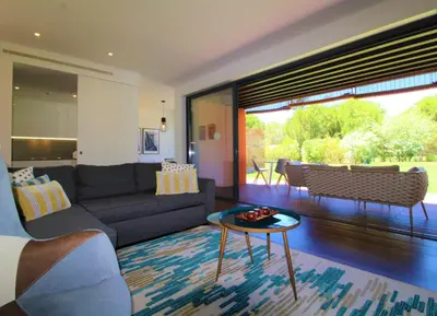 a living room with a couch and a table at L'Orangerie Green Garden by SAPvillas in Vilamoura