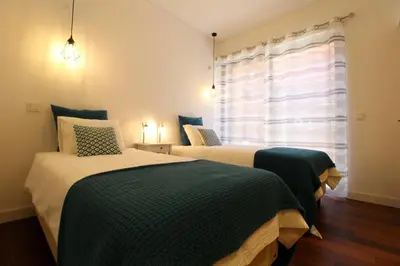 two beds in a room with a window at L'Orangerie Green Garden by SAPvillas in Vilamoura