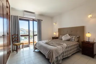 a bedroom with a bed and a balcony at Villa Canto II - 500m from the Beach - Private Swimming Pool - Wi Fi in Guia