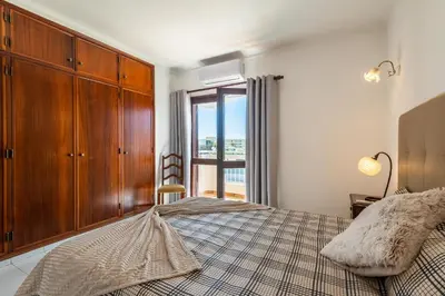 a bedroom with a bed with a dresser and a window at Villa Canto II - 500m from the Beach - Private Swimming Pool - Wi Fi in Guia