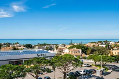 a view of a building with a solar roof and the ocean at Albufeira Beach Apartment in Guia
