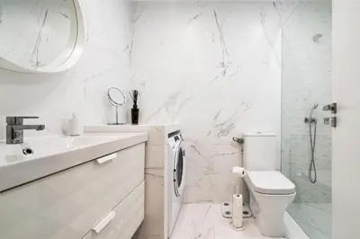 a white bathroom with a toilet and a sink at Albufeira Beach Apartment in Guia