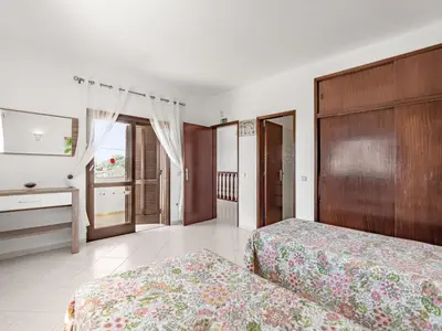 a hotel room with two beds and a television at Holiday Home Vivenda Deolinda by Interhome in Albufeira