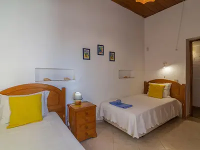 a bedroom with two beds with yellow pillows and a night stand at Villa Villa Genoveva by Interhome in Albufeira