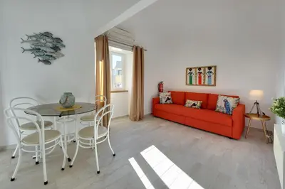 a living room with a red couch and a table at Apartamentos Tucha in Albufeira