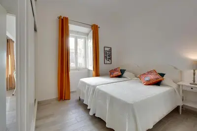 a bedroom with two beds and a window at Apartamentos Tucha in Albufeira