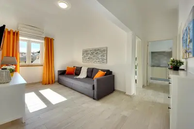 a living room with a couch and orange curtains at Apartamentos Tucha in Albufeira