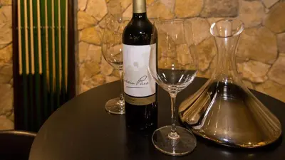 a bottle of wine and two wine glasses on a table at Dream Villa with Luxury Services - PROMOTION Last dates! in Vilamoura