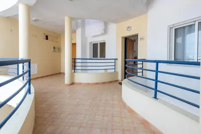a large room with blue railing and a hallway at Apartamento Monarquia - T3 Quarteira in Quarteira