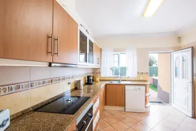 a kitchen with wooden cabinets and a sink at Villa Bali by Algarve Vacation in Albufeira