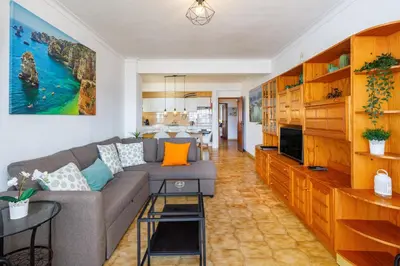 a living room with a couch and a tv at Apartamento Vista Mar T2 in Quarteira