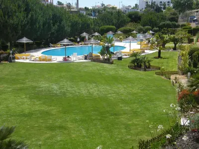 a large green yard with a swimming pool at Luxurious first floor apartment with balconies overlooking pool and gardens. in Albufeira