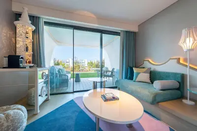 a bedroom with a large bed and a living room at W Algarve in Albufeira