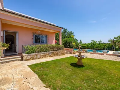 a house with a garden with a fountain in the yard at Holiday Home Isaurinda by Interhome in Faro