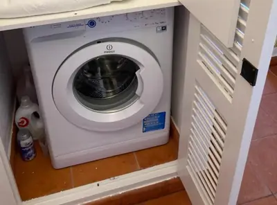 a washing machine in a cabinet in a kitchen at Solar dos Pinheiros LC 303 in Quarteira