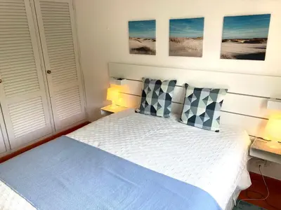 a bedroom with a bed with two pillows and two lamps at Solar dos Pinheiros LC 303 in Quarteira