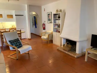 a living room with a fireplace and a dining room at Solar dos Pinheiros LC 303 in Quarteira