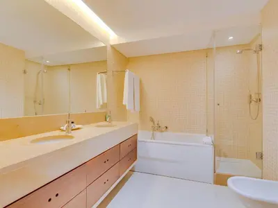 a white bed with white sheets and pillows at Vale do lobo, 'Golf by the Pool' 2 bedroom apartment in Vale do Lobo
