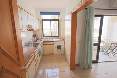 a kitchen with a sink and a washing machine at Apartamentos Ninho das Gaivotas in Albufeira