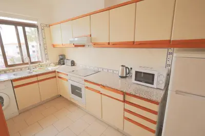 a kitchen with a white refrigerator and a microwave at Apartamentos Ninho das Gaivotas in Albufeira