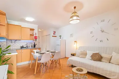 a kitchen and a living room with a couch and a table at Sea & Sun OldTown in Albufeira