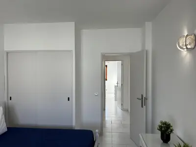 a bedroom with a blue bed and a hallway at Sta. Eulalia Mar A36 in Albufeira