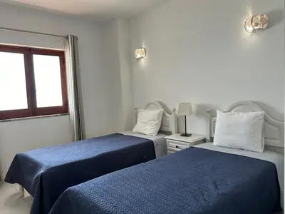 two beds in a white room with blue sheets at Sta. Eulalia Mar A36 in Albufeira