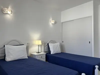 a bedroom with two blue beds and a mirror at Sta. Eulalia Mar A36 in Albufeira