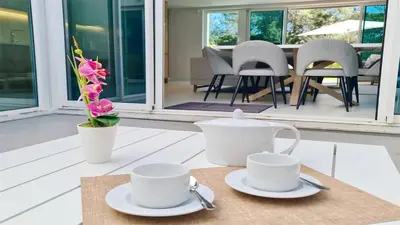two white cups and saucers on a table on a porch at Villa Sadler- Clever Details, Central Vilamoura, Sleeps 6, luxury, walking distance in Vilamoura
