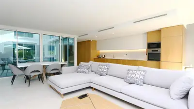 a living room with a white couch and a table at Villa Sadler- Clever Details, Central Vilamoura, Sleeps 6, luxury, walking distance in Vilamoura