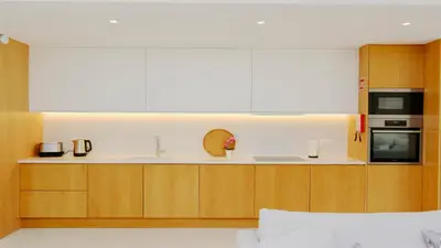 a kitchen with wooden cabinets and a white counter top at Villa Sadler- Clever Details, Central Vilamoura, Sleeps 6, luxury, walking distance in Vilamoura