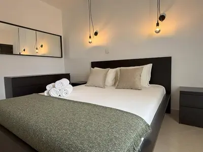 a bedroom with a bed with two towels on it at Go4Portugal - Lagoa - Apartment 3 min from beach with airco and balcony in Quarteira