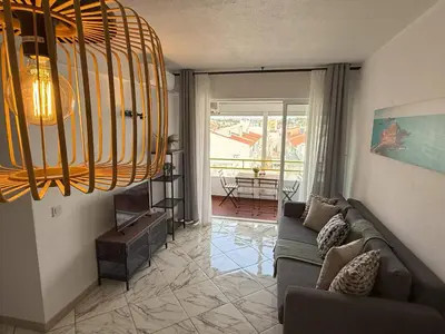 a living room with a couch and a chandelier at Go4Portugal - Lagoa - Apartment 3 min from beach with airco and balcony in Quarteira