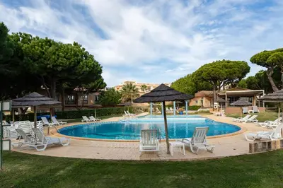 a pool with chairs and umbrellas in a yard at Pedra dos Bicos by Intiholidays in Albufeira