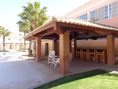 a pavilion with a table and chairs in front of a building at Santa Maria G by Check-in Portugal in Albufeira