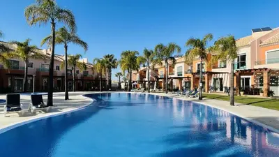 a large swimming pool with chairs and palm trees at Santa Maria G by Check-in Portugal in Albufeira
