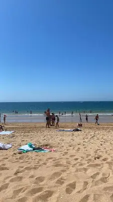 a group of people on a beach with the ocean at Albufeira Garden in Albufeira