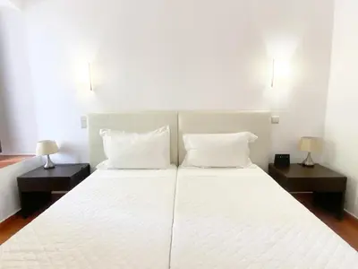 a bedroom with a large white bed with two night stands at Albufeira Garden in Albufeira