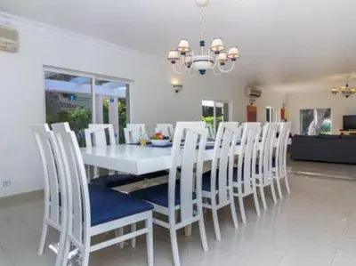 a dining room with a white table and chairs at Vilamoura Golf Mansion by Stay ici Algarve Holiday Rental in Quarteira