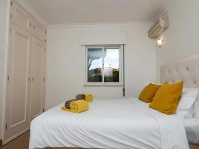 a bedroom with a large white bed with yellow pillows at Vilamoura Golf Mansion by Stay ici Algarve Holiday Rental in Quarteira